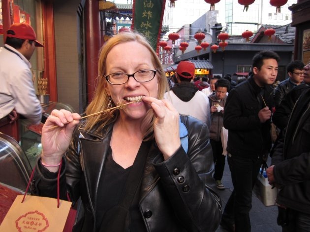 中国北京，一名女子正在吃蝎子。