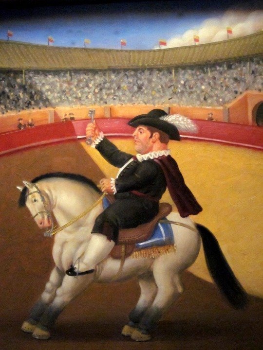 一幅在体育场骑马的男人的画。