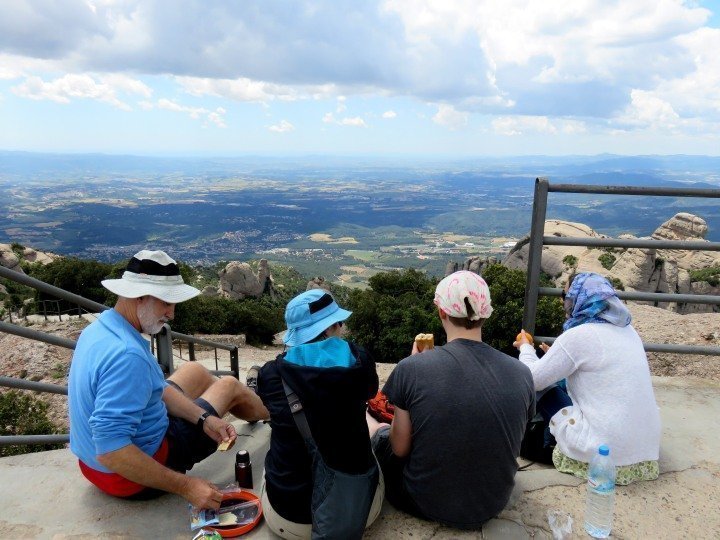 四名徒步旅行者在圣杰罗尼山顶吃午餐。