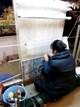 织布机前的女人正在编织丝毯。