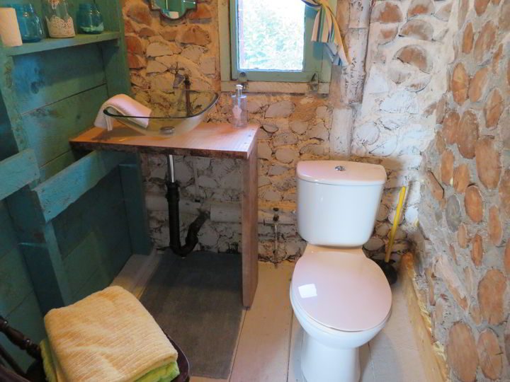 带有彩色绿松石架子的基本浴室满足了基本需求-淋浴位于独立的建筑中
