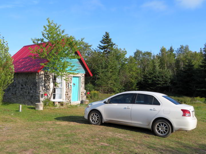 在布雷顿角高地国家公园附近的卡伯特小道上，一所涂着蓝绿色、屋顶是红色的小房子