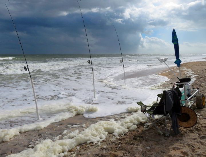 在佛罗里达州维拉诺海滩(Vilano beach)，钓鱼杆排列在海滩上，等待着捕鱼——这是最好的钓鱼场所之一。