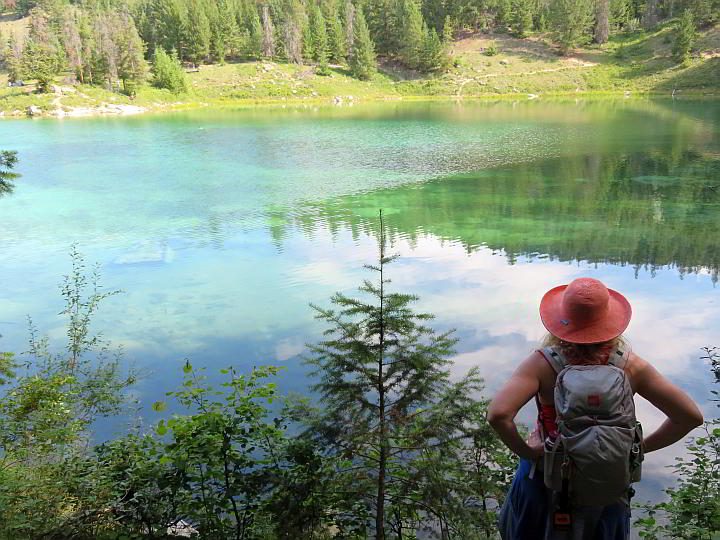 女徒步旅行者看着绿松石湖沿着山谷的五湖远足在碧玉AB