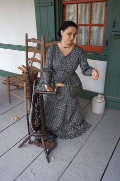 在Vermilionville历史村，一名女子正在纺纱。