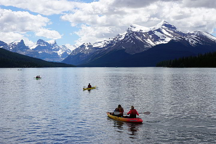 在加拿大的贾斯帕湖，大雪覆盖的落基山脉为皮划艇爱好者提供了全景视野