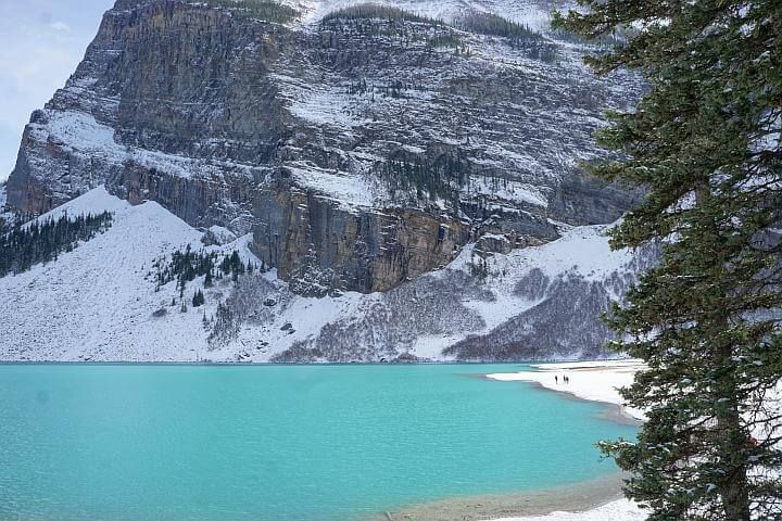 露易丝湖明亮的绿松石水与白雪覆盖的山的背景