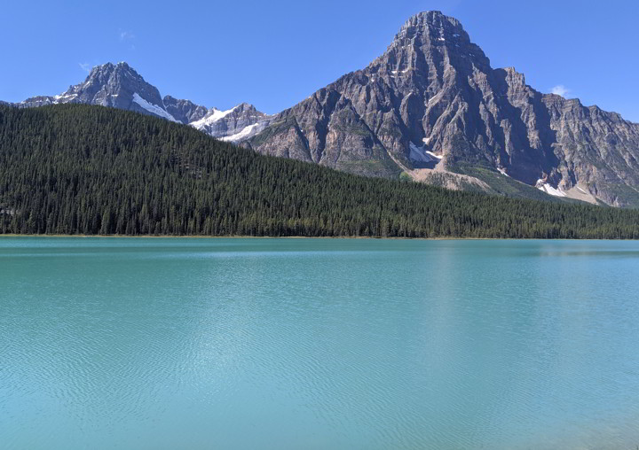 明亮的蓝色水鸟湖与崎岖的落基山脉为背景