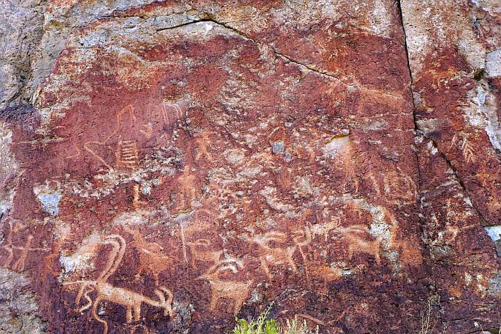 描绘人和动物的岩石雕刻在红色的岩石上。