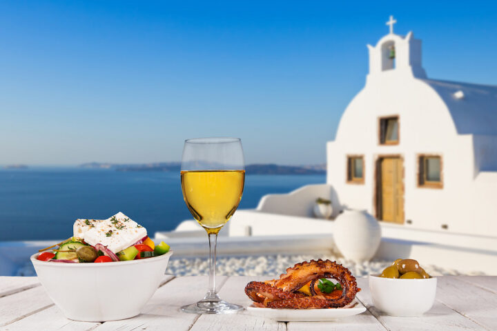 一杯白葡萄酒、橄榄、章鱼和希腊沙拉——希腊的传统食物。