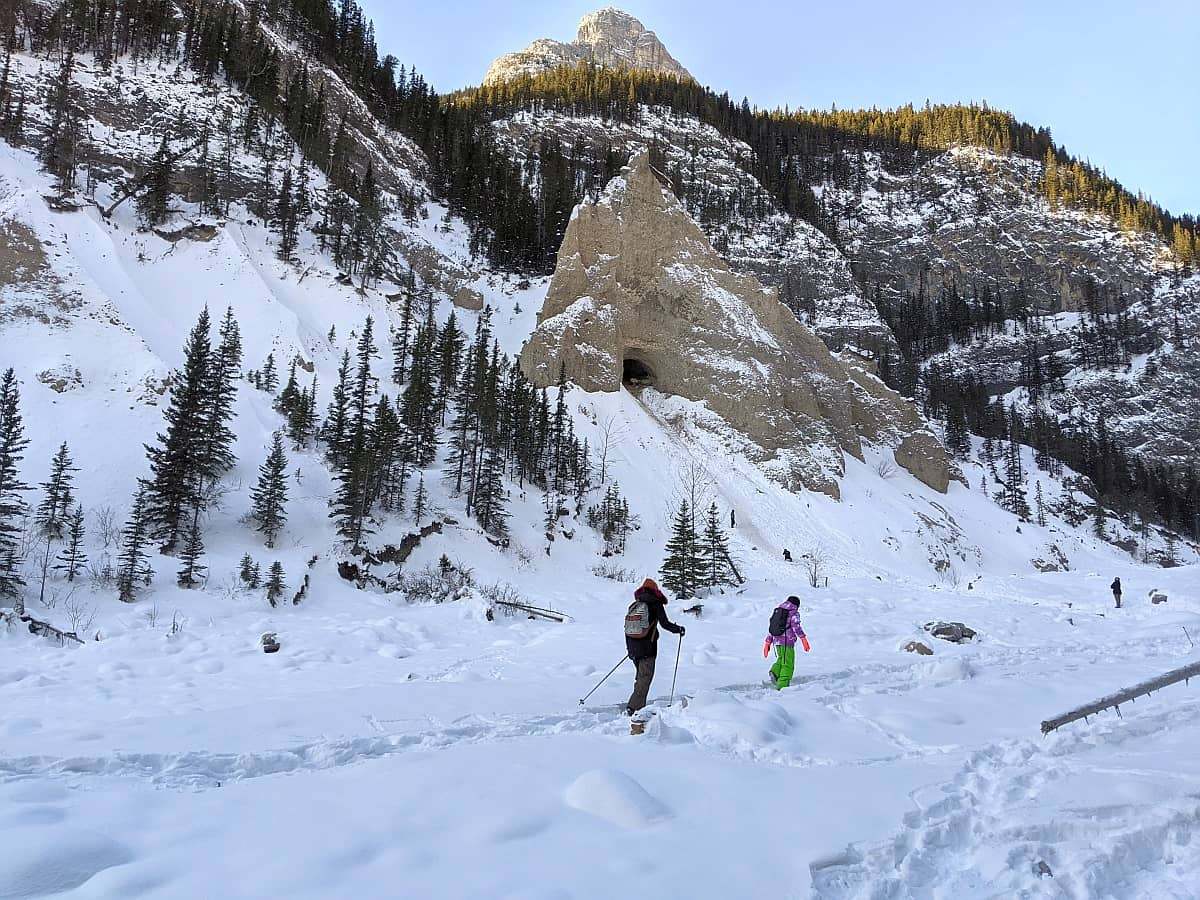 两个穿着冬季徒步装备的徒步旅行者走在雪道上。