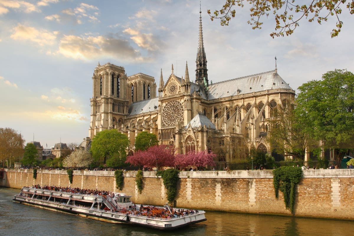 游客在塞纳河游船在巴黎圣母院前。