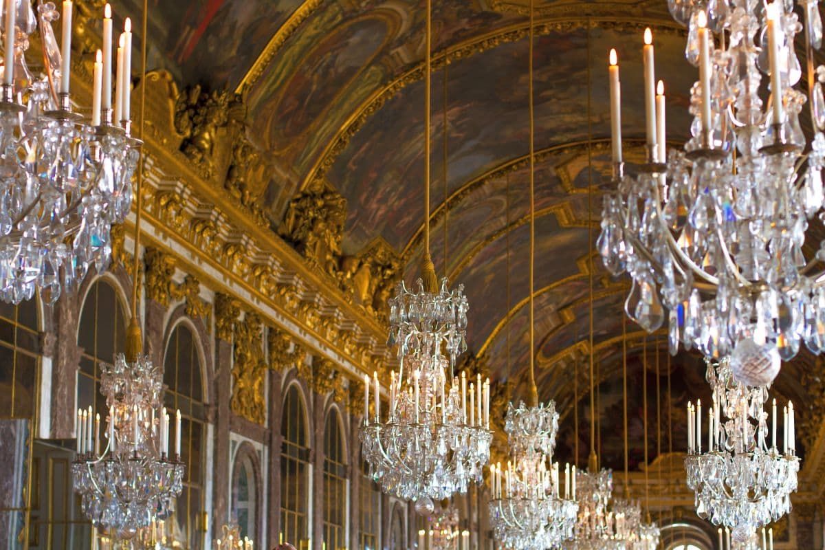 凡尔赛宫中华丽的吊灯挂在大厅的镜子上。