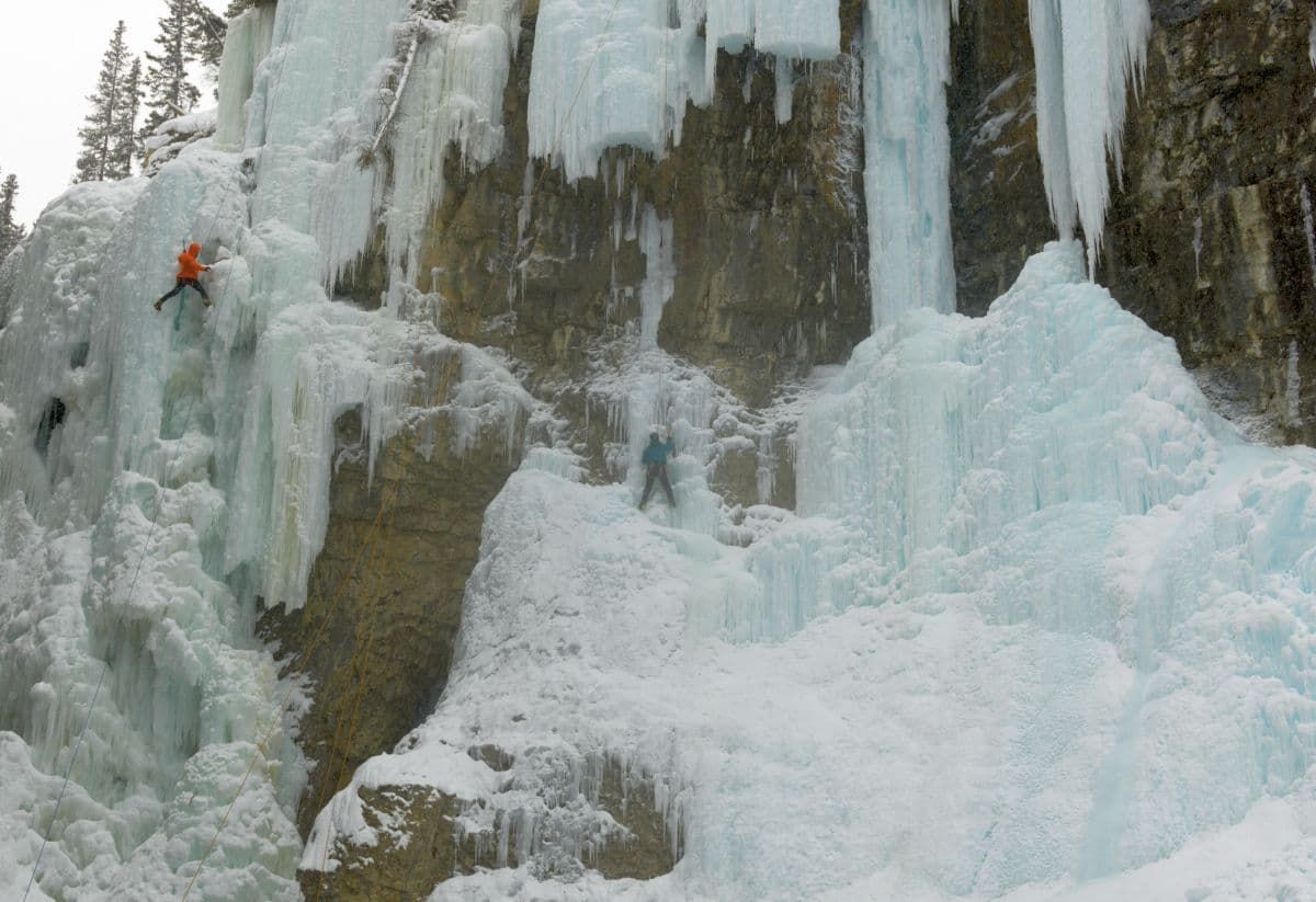 约翰斯顿峡谷冰上攀登者在班夫冬季冰冻的瀑布上。
