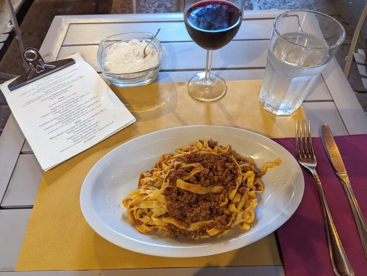 意大利面，帕尔玛干酪，红酒，水，和菜单。